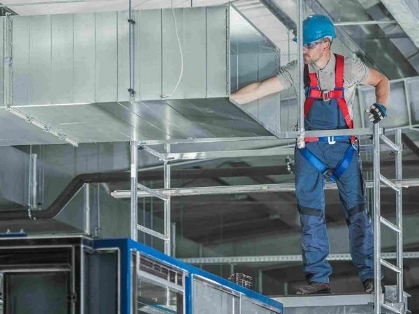 nhân viên lắp đoạn ống gió cứng chữ nhật trên cao